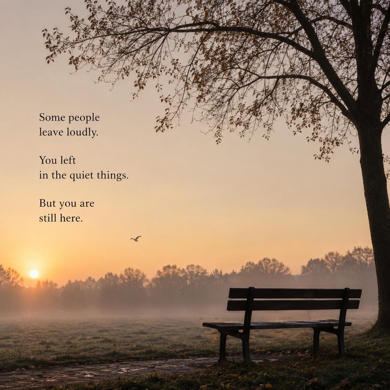 An empty park bench beneath a bare tree at sunrise, mist lying over the grass and a single bird crossing a golden sky.
